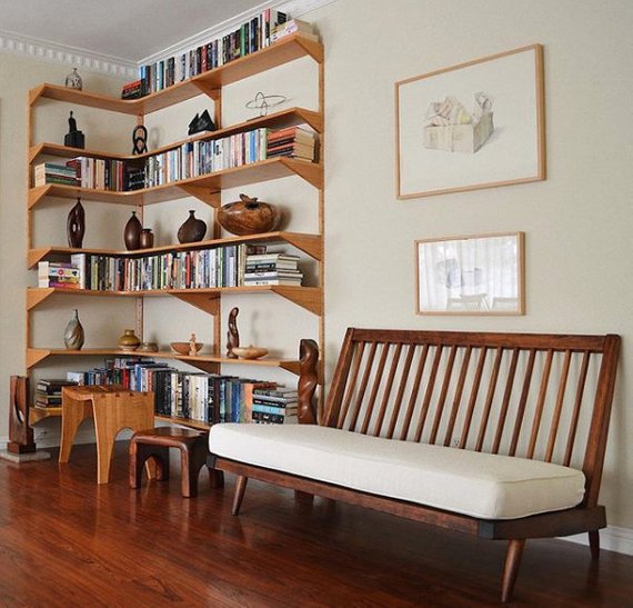 early George Nakashima settee next to bookcase featuring other studio craft vessels and sculptures